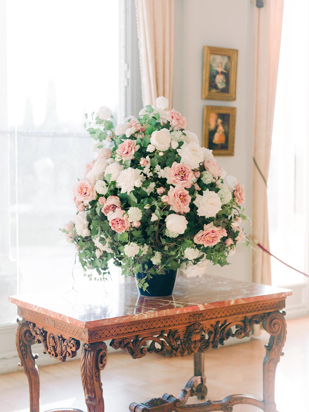 Pink and white floral arrangement inside a historic villa salon